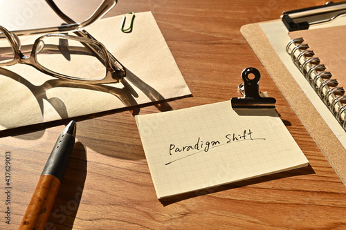 Foto There is a piece of paper with the word paradigm shift on the desk with a glasses and clipboard