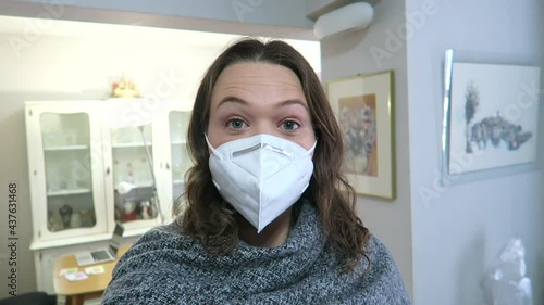 Attractive woman vlogging at home, wearing a face mask