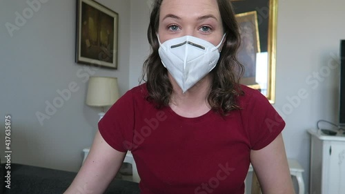 Beautiful woman putting on face mask, scarf and black gloves for winter.