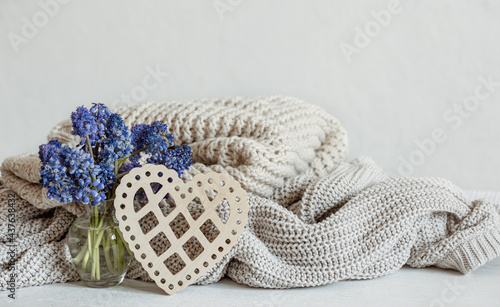 Cozy composition with flowers, knitted items and a decorative heart.