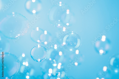 Beautiful Transparent Soap Bubbles Float on Blue Background.