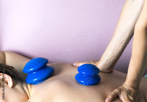 The postpartum doula placed vacuum silicone cups on the woman's back. Postpartum recovery of a woman. High quality photo