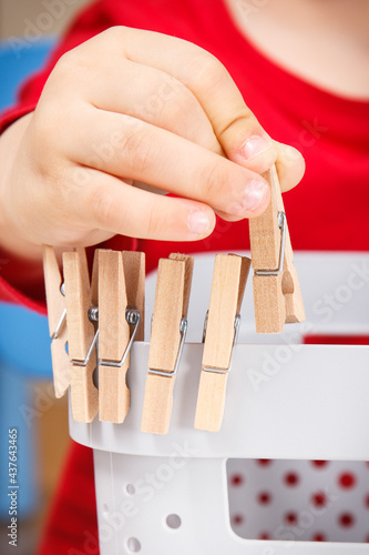 Preschooler playing with wooden clip. Development of kids motor skills and coordination