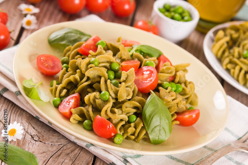 Fusilli pasta with cherry tomatoes and peas.