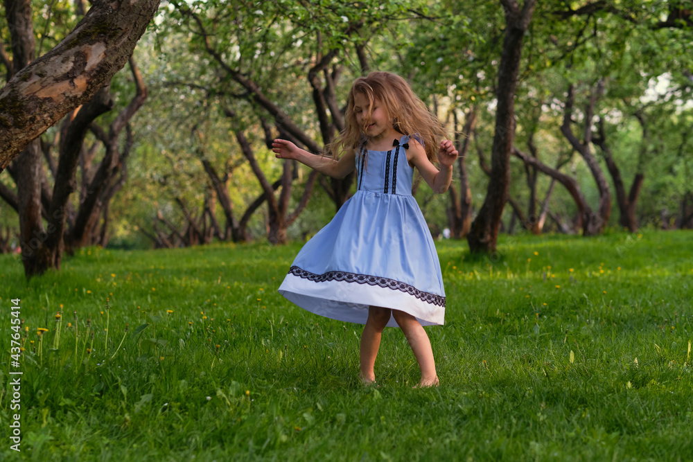 little girl runs barefoot on the grass. happy child on a hot summer day. little girl runs barefoot on the grass. happy child on a hot summer day.