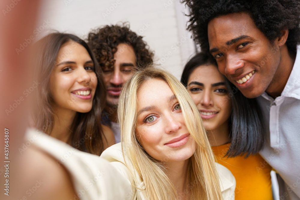 Multi-ethnic group of friends taking a selfie together while having fun outdoors. Multi-ethnic group of friends taking a selfie together while having fun outdoors.