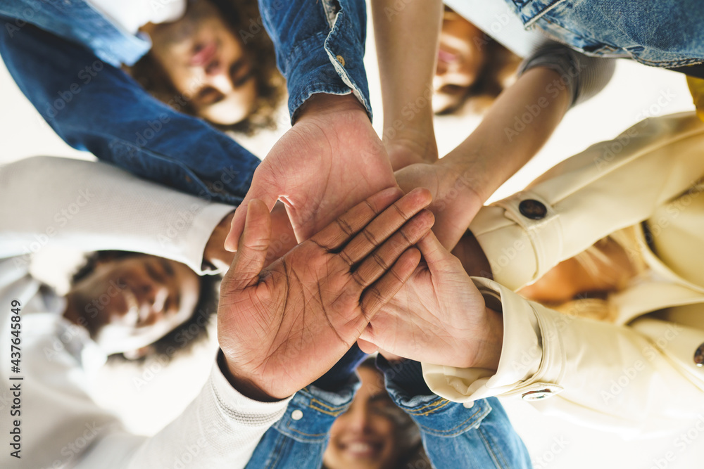 Obraz premium Hands of a multi-ethnic group of friends joined together as a sign of support and teamwork.