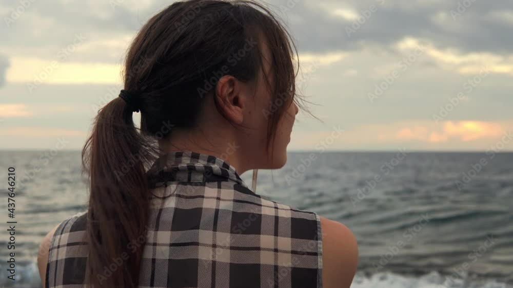 Woman admires the beautiful sky while sitting on the seashore. 4k footage Woman admires the beautiful sky while sitting on the seashore. 4k footage