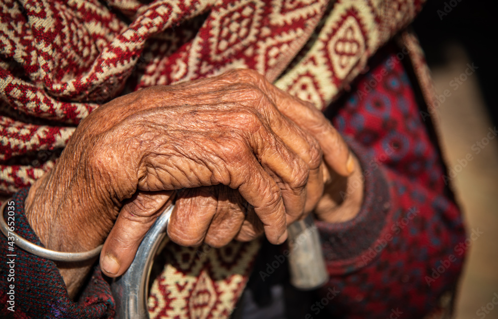 Close up  of the crossed wrinkle hands of an elder grandmother nepalese woman.