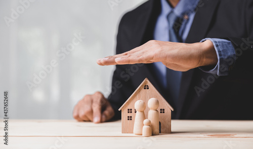 Insurance house, and family health live concept. The insurance agent presents the ้hands protection model that symbolize the coverage.