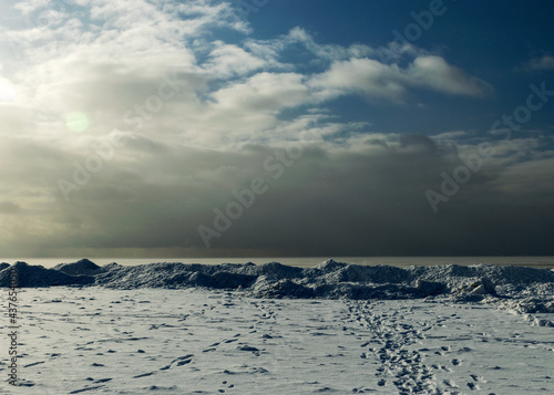 winter landscape by the sea, snowy pieces of ice by the sea, dunes covered with a white layer of shining snow