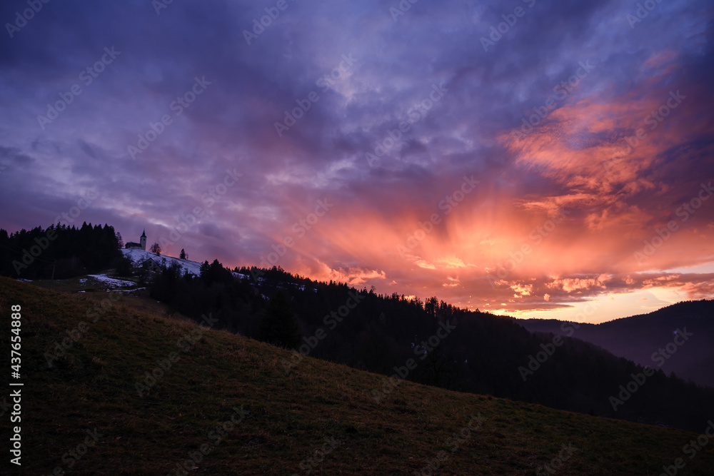 Dramatic orange sunset above Sv.Ozbolt hill in Slovenia