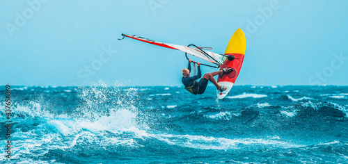 watersport: windsurfer jumping among waves of the blue ocean during a summer vacation
 photo