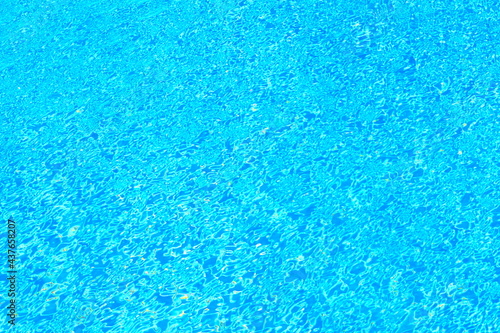 Top view of beautiful swimming pool with clear water and sunlight reflection on the surface in bright blue tone
