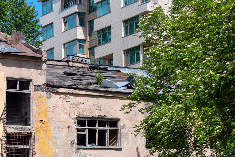 Old abandoned house and new apartment building Old abandoned house and new apartment building
