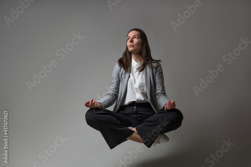 Foto Meditation and stress control at work, a young woman in a business suit,