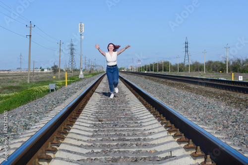 Teenage girl is running along railroad, catching up with departed train. Lady was late for the trip