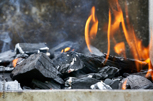 Blazing flames in a charcoal grill. Hot embers. Closeup. Front view.