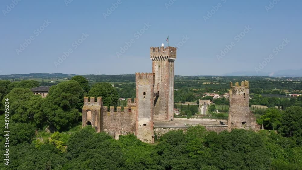 Castle Scaligero in Valeggio sul Mincio, Verona, Italy. Aerial view of the Italian historic castle Castello Scaligero on a hill, view of the Ponte Visconteo bridge and the Mincio river. Castle Scaligero in Valeggio sul Mincio, Verona, Italy. Aerial view of the Italian historic castle Castello Scaligero on a hill, view of the Ponte Visconteo bridge and the Mincio river.