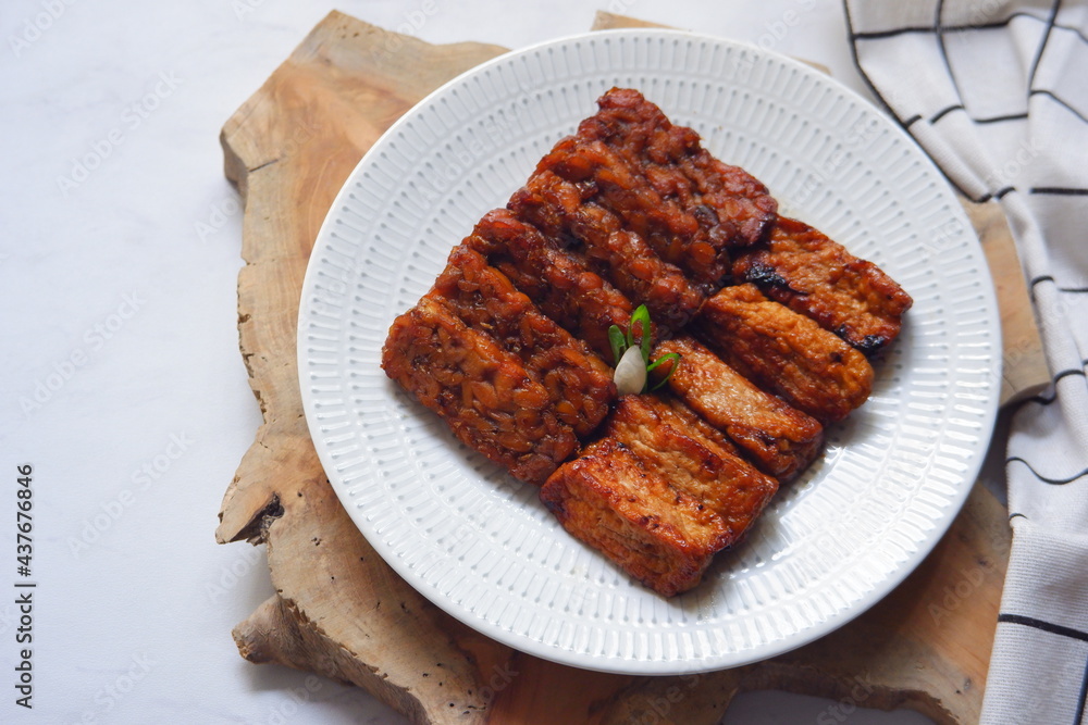 a plate of tempeh and tofu cooked in sweet soy sauce 