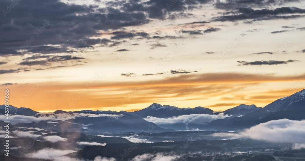 Time lapse of beautiful colorful sunset in Slovenia. Elevated view of vibrant clouds moving over amazing landscape. Fog rolling in the valley. Zoom in, wide angle Time lapse of beautiful colorful sunset in Slovenia. Elevated view of vibrant clouds moving over amazing landscape. Fog rolling in the valley. Zoom in, wide angle