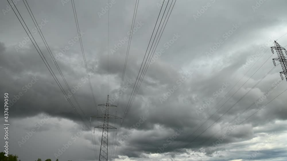 Time lapse view of storm clouds moving over high voltage electric towers. Electricity steel pylon tower. Low angle view of power line. Static shot, wide angle Time lapse view of storm clouds moving over high voltage electric towers. Electricity steel pylon tower. Low angle view of power line. Static shot, wide angle