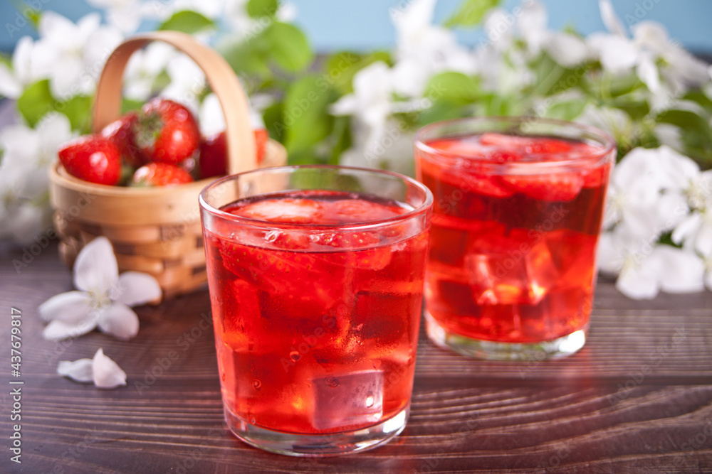 Strawberry cold refreshment lemonade with ice cube. White apple blossoms on the background. Spring concept. Strawberry cold refreshment lemonade with ice cube. White apple blossoms on the background. Spring concept.