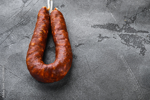 Spanish sausage chorizo salami on grey textured background with copy space