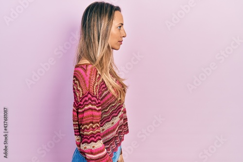 Beautiful hispanic woman wearing hippie sweater looking to side, relax profile pose with natural face with confident smile.