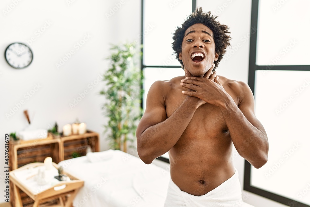 Young african american man shirtless wearing towel standing at beauty ...