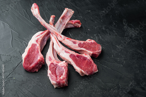 Raw lamb chops or mutton cuts, on black stone background , with copyspace  and space for text