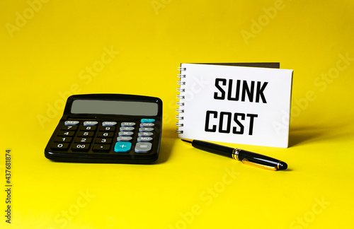 Notepad with calculator, pen and writing on the notepad SUNC COST photo