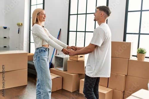 Young caucasian couple smiling happy dancing at new home.