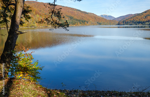 Forest meadow on shore of picturesque lake. Vilshany water reservoir on the Tereblya river, Transcarpathia, Ukraine. Beautiful autumn day in Carpathian Mountains. photo