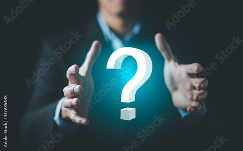 Ask question online concept, Businessman hand hold interface question marks sign web, Question marks drawn on black background. Concept of searching for an answer, Uncertainty and problem solving.