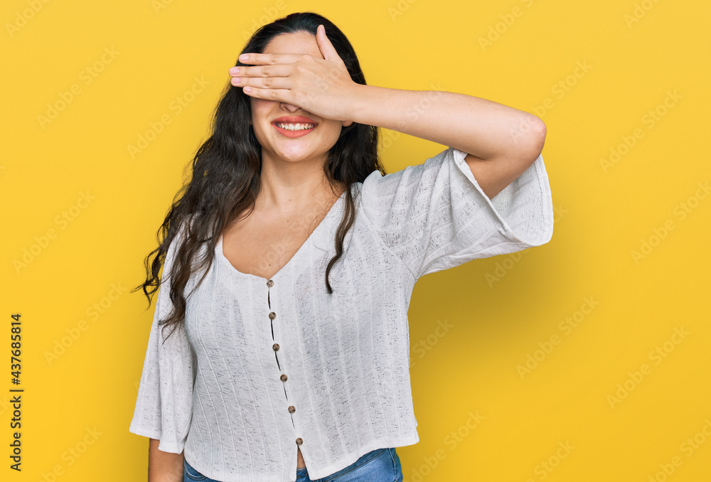 Brunette young woman wearing casual clothes smiling and laughing with hand on face covering eyes for surprise. blind concept.