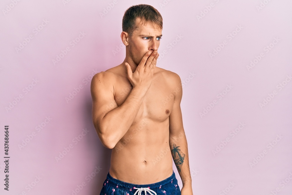 Young caucasian man wearing swimwear bored yawning tired covering mouth with hand. restless and sleepiness.