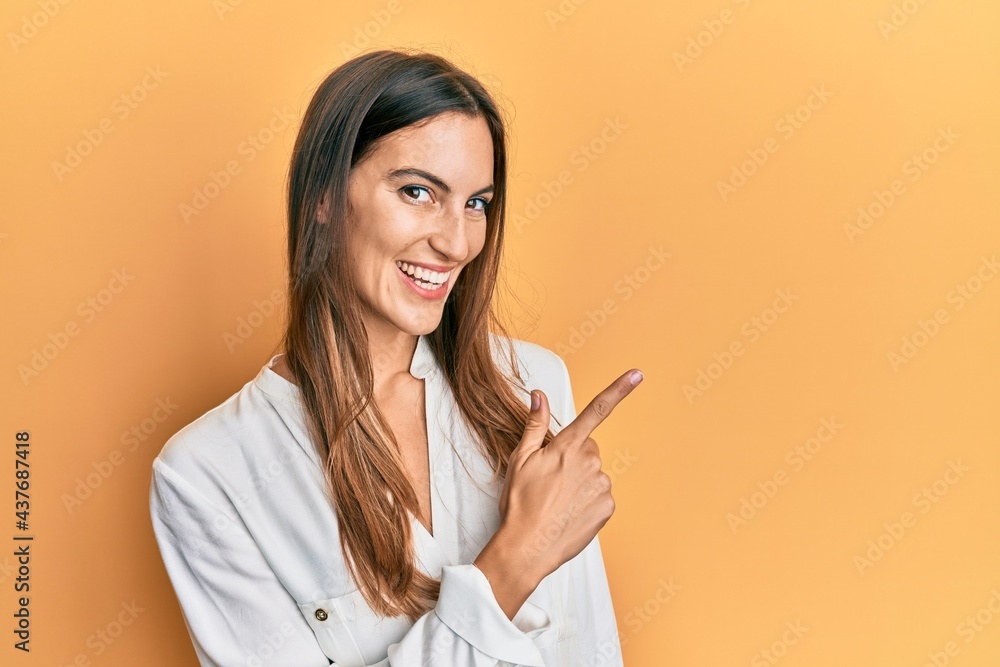 Young beautiful woman wearing casual clothes smiling cheerful pointing with hand and finger up to the side Young beautiful woman wearing casual clothes smiling cheerful pointing with hand and finger up to the side
