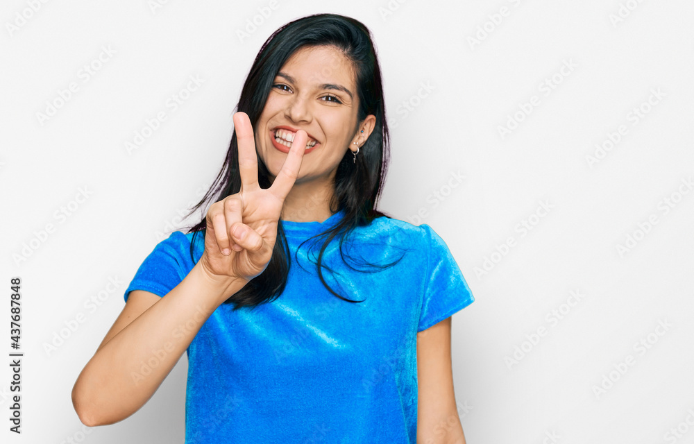 Young hispanic woman wearing casual clothes showing and pointing up with fingers number two while smiling confident and happy. Young hispanic woman wearing casual clothes showing and pointing up with fingers number two while smiling confident and happy.