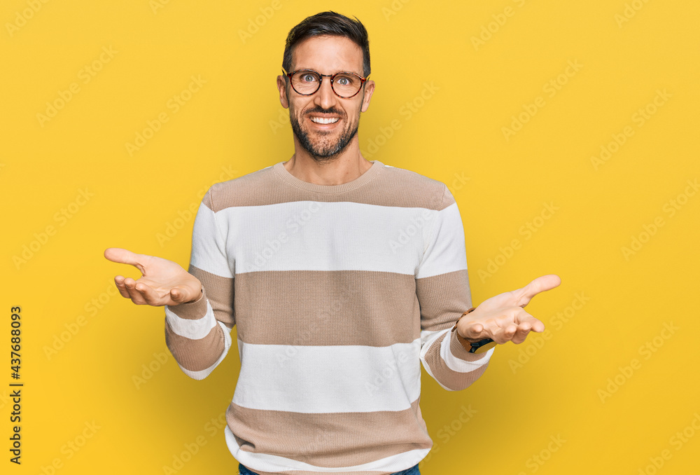 Handsome man with beard wearing casual clothes and glasses smiling cheerful with open arms as friendly welcome, positive and confident greetings Handsome man with beard wearing casual clothes and glasses smiling cheerful with open arms as friendly welcome, positive and confident greetings