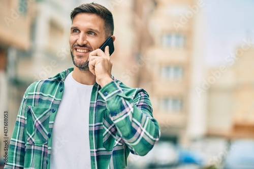 Young caucasian man smiling happy talking on the smartphone at the city.