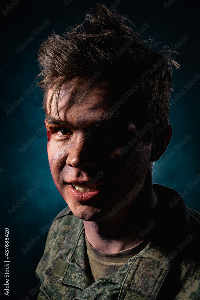Portrait of a close-up of an aggressive military in scars and battle paint against a backdrop of blue smoke Portrait of a close-up of an aggressive military in scars and battle paint against a backdrop of blue smoke