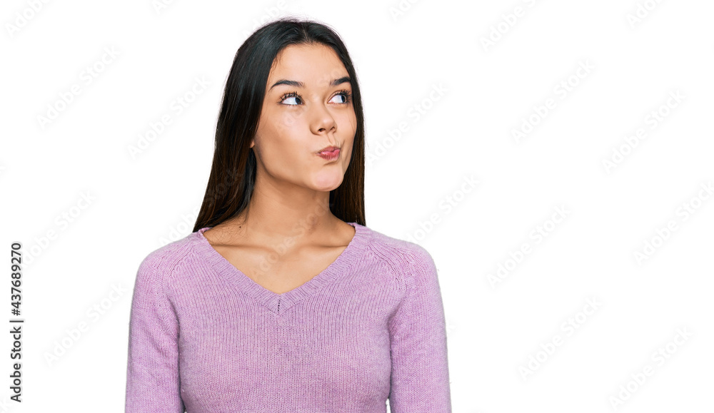 Young hispanic girl wearing casual clothes smiling looking to the side and staring away thinking. Young hispanic girl wearing casual clothes smiling looking to the side and staring away thinking.