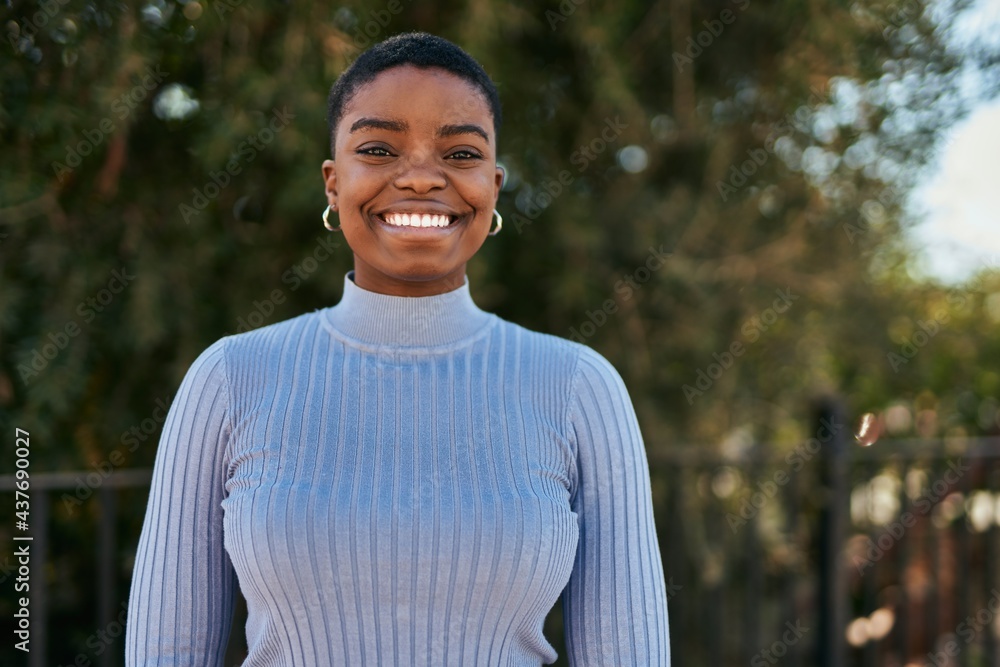 Young african american woman smiling happy standing at the park. Young african american woman smiling happy standing at the park.