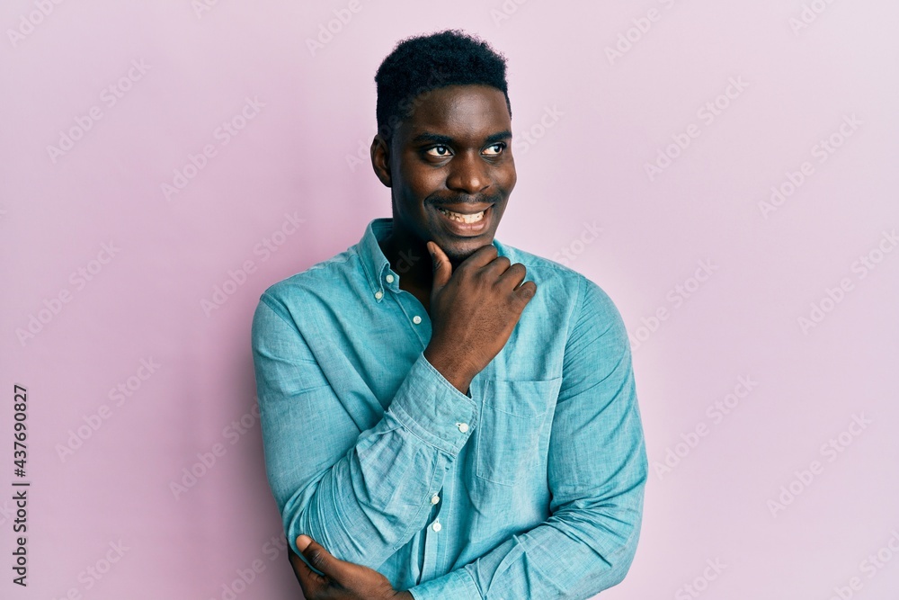 Handsome black man wearing casual clothes with hand on chin thinking about question, pensive expression. smiling with thoughtful face. doubt concept. Handsome black man wearing casual clothes with hand on chin thinking about question, pensive expression. smiling with thoughtful face. doubt concept.