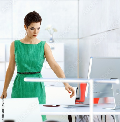 Short haired female office worker busy at office.