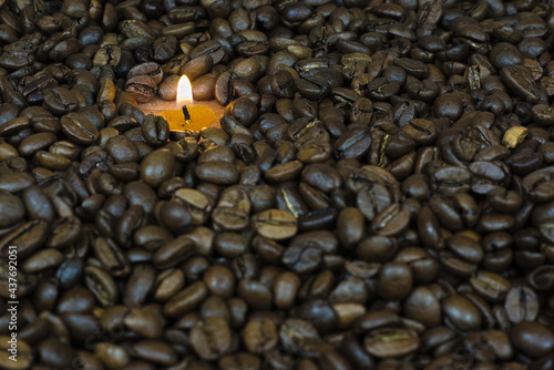 scattered coffee beans in the background a small candle