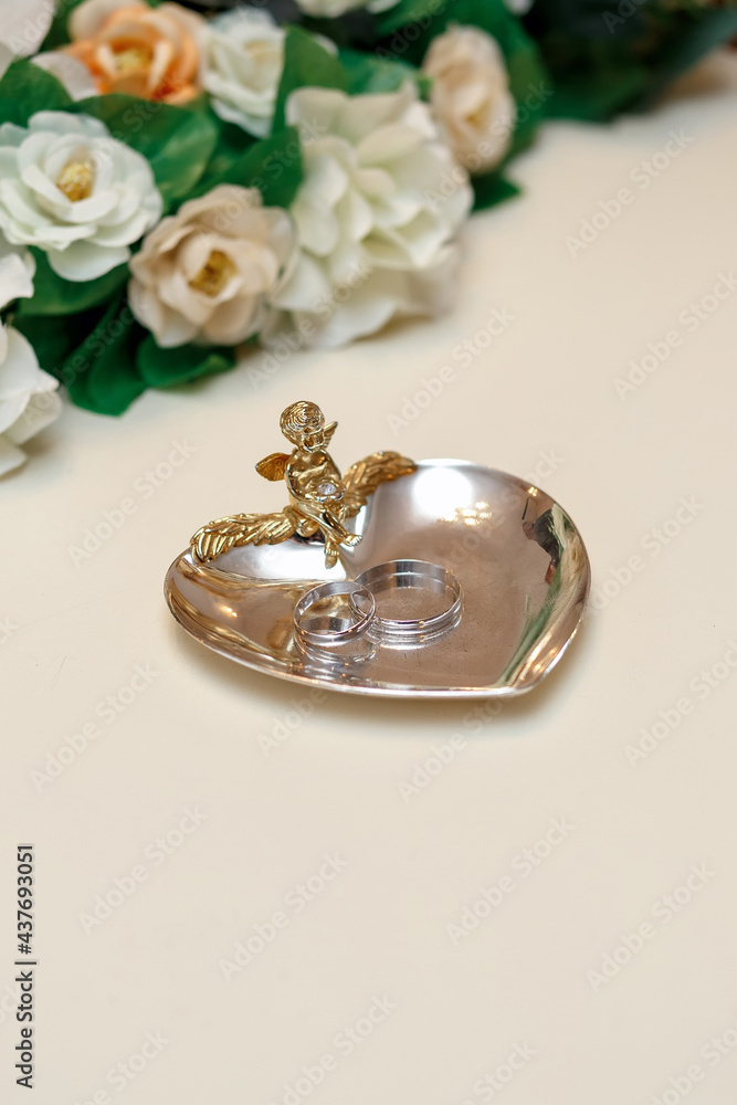 two rings of precious metals on a silver metal stand with gold trim two rings of precious metals on a silver metal stand with gold trim