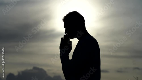 Silhouette of Man pray on during sunset. Religion, faith and hope concept  photo