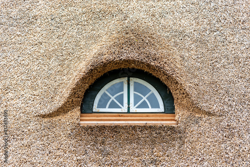 Fenster im Dach einer Reetdachkate